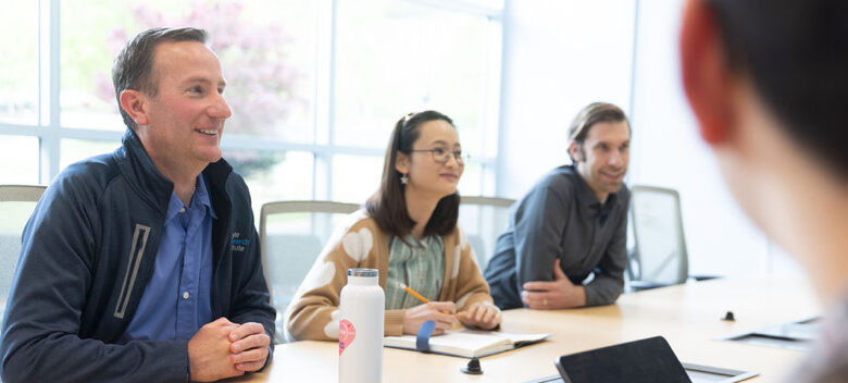 Group of people sitting around a conference table and talking